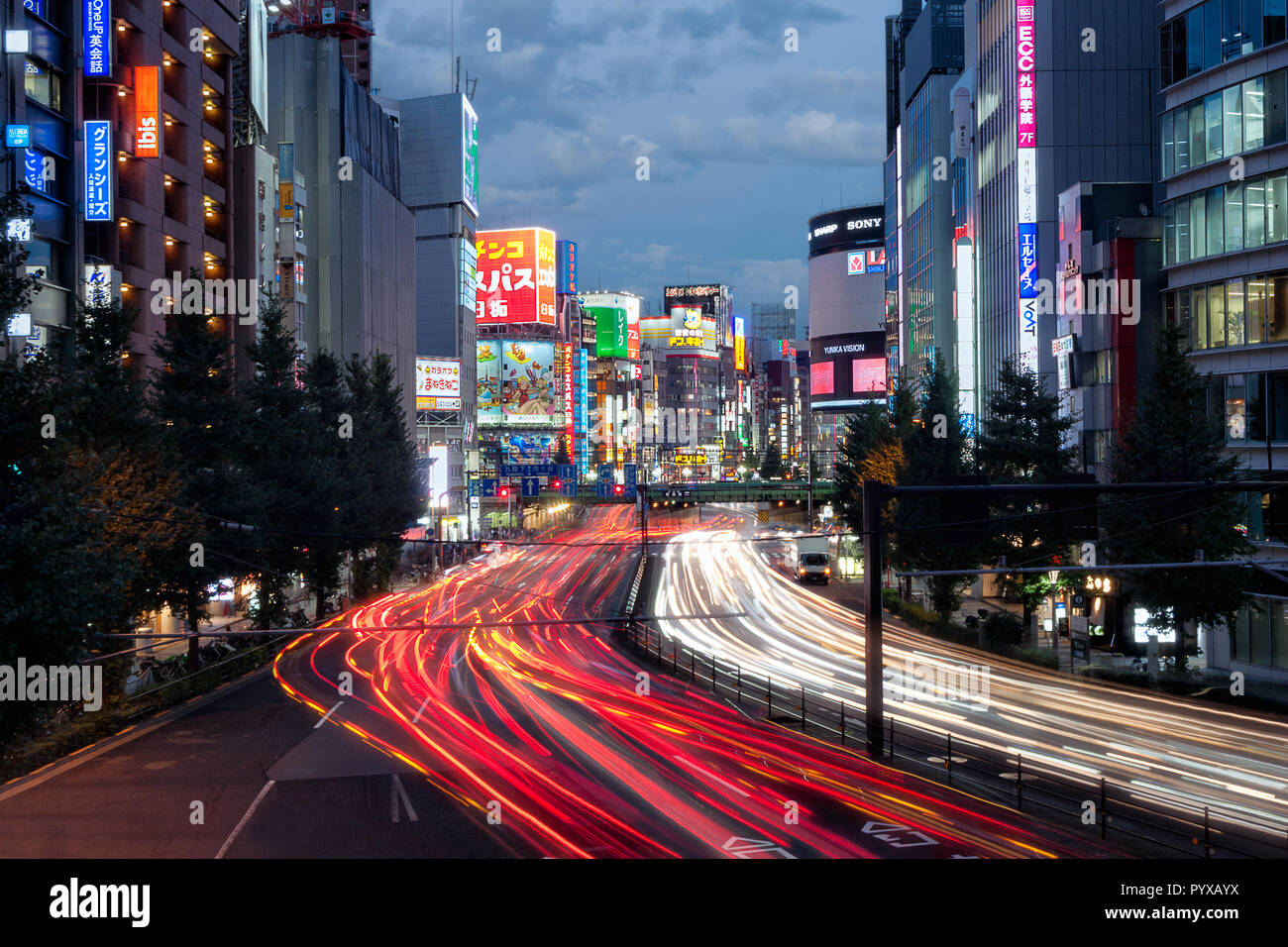 Auto sentieri di luce sulla trafficata strada vicino alla stazione di Shinjuku a Tokyo in Giappone Foto Stock