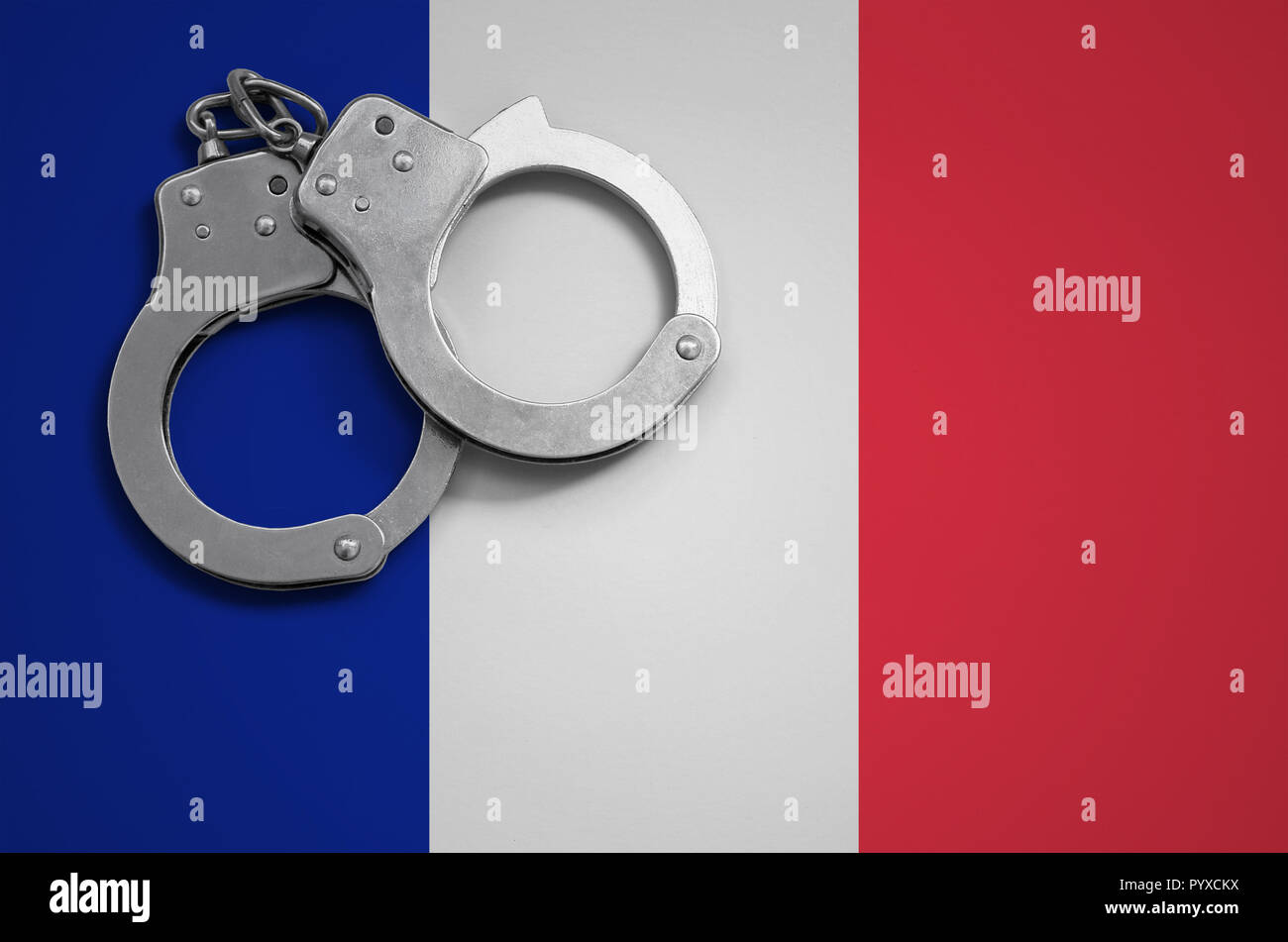 Bandiera della Francia e forze di polizia in manette. Il concetto di criminalità e i reati nel paese. Foto Stock