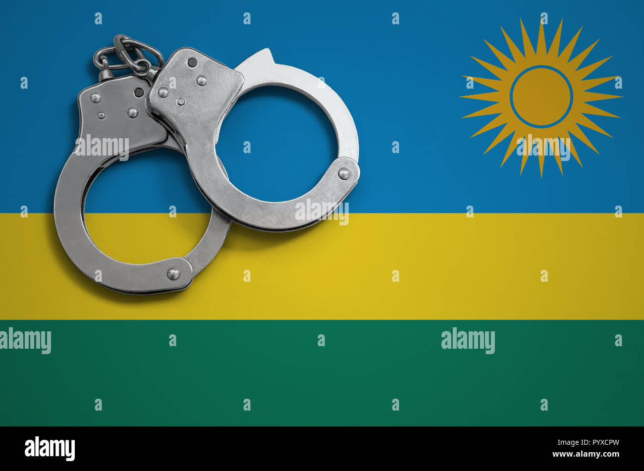 Ruanda bandiera e manette di polizia. Il concetto di criminalità e i reati nel paese. Foto Stock