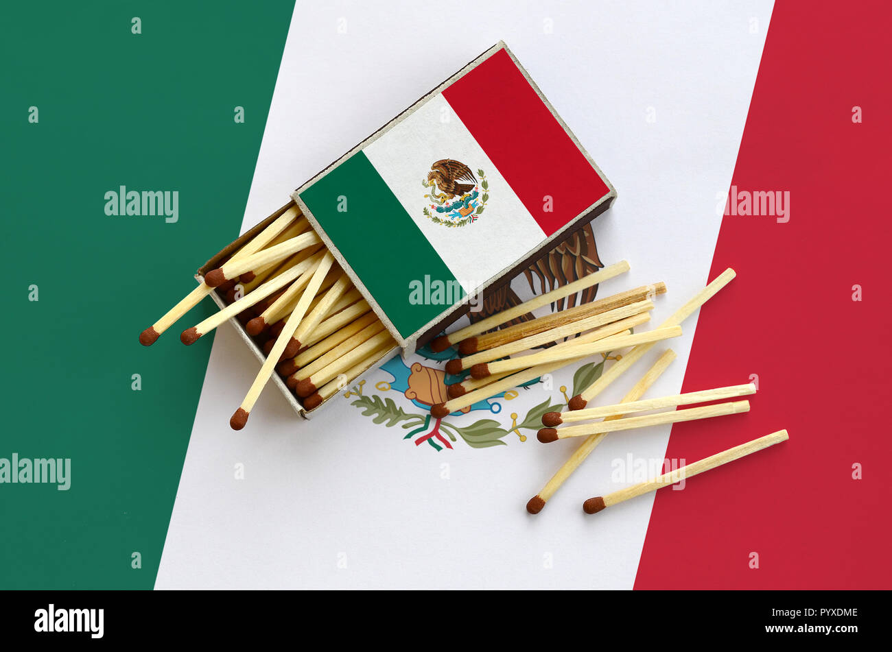Bandiera del Messico è mostrato su un open matchbox, da cui diversi corrisponde a caduta e giace su di una bandiera di grandi dimensioni. Foto Stock