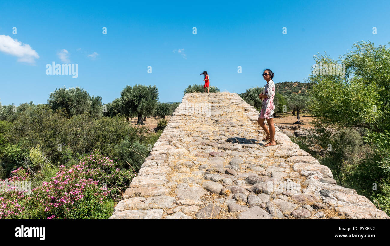 Ragazza in abito rosso in piedi sul ponte antico Foto Stock