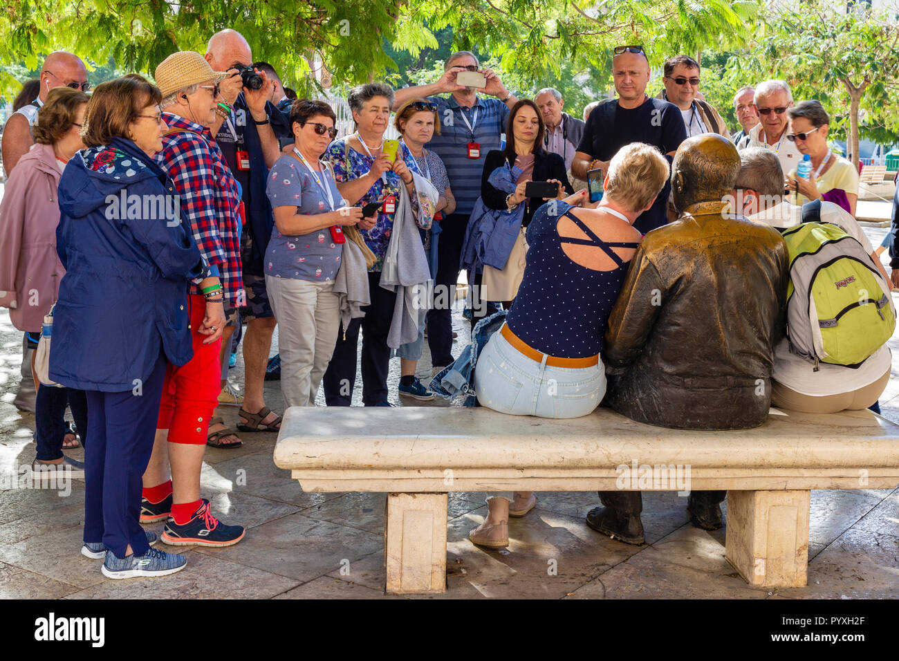 Gruppo di Tour fotografie di Pablo Picasso statua in Plaza Merced, Malaga, Andalusia, Spagna Foto Stock