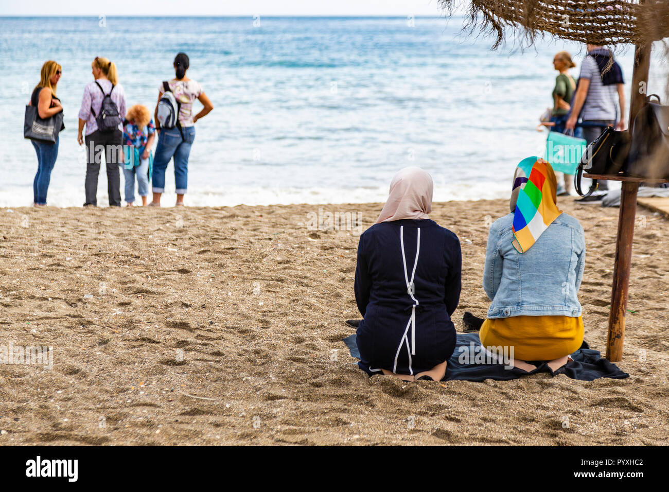 Le donne musulmane pregando sulla spiaggia, Malaga, Andalusia, Spagna Foto Stock