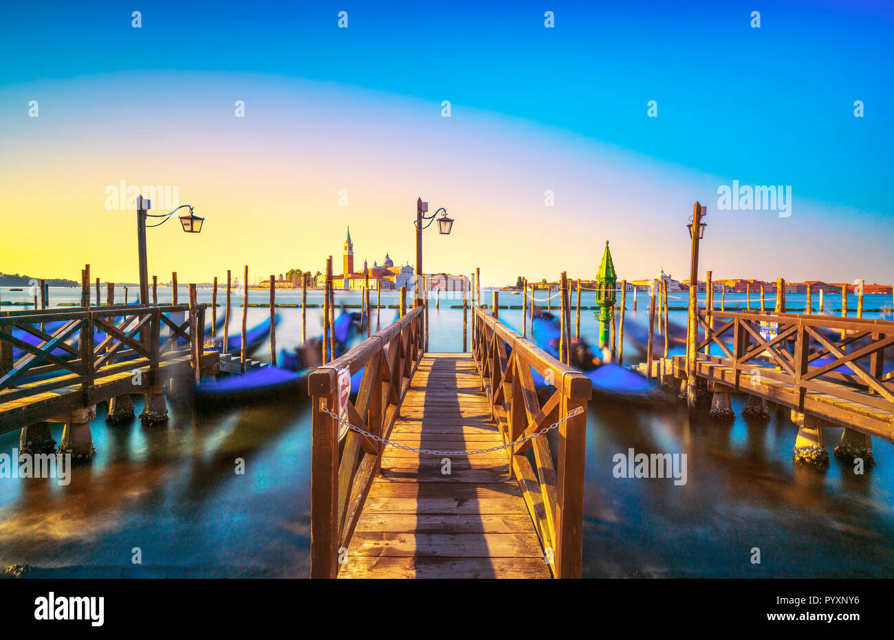 La laguna di Venezia al sunrise, chiesa di San Giorgio Maggiore, le gondole e i poli. L'Italia, l'Europa. Foto Stock