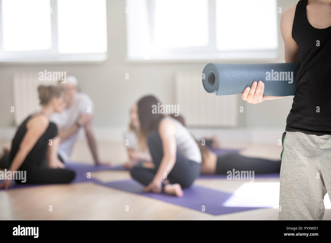Irriconoscibile uomo con materassino yoga gruppo sportivi su backg Foto Stock
