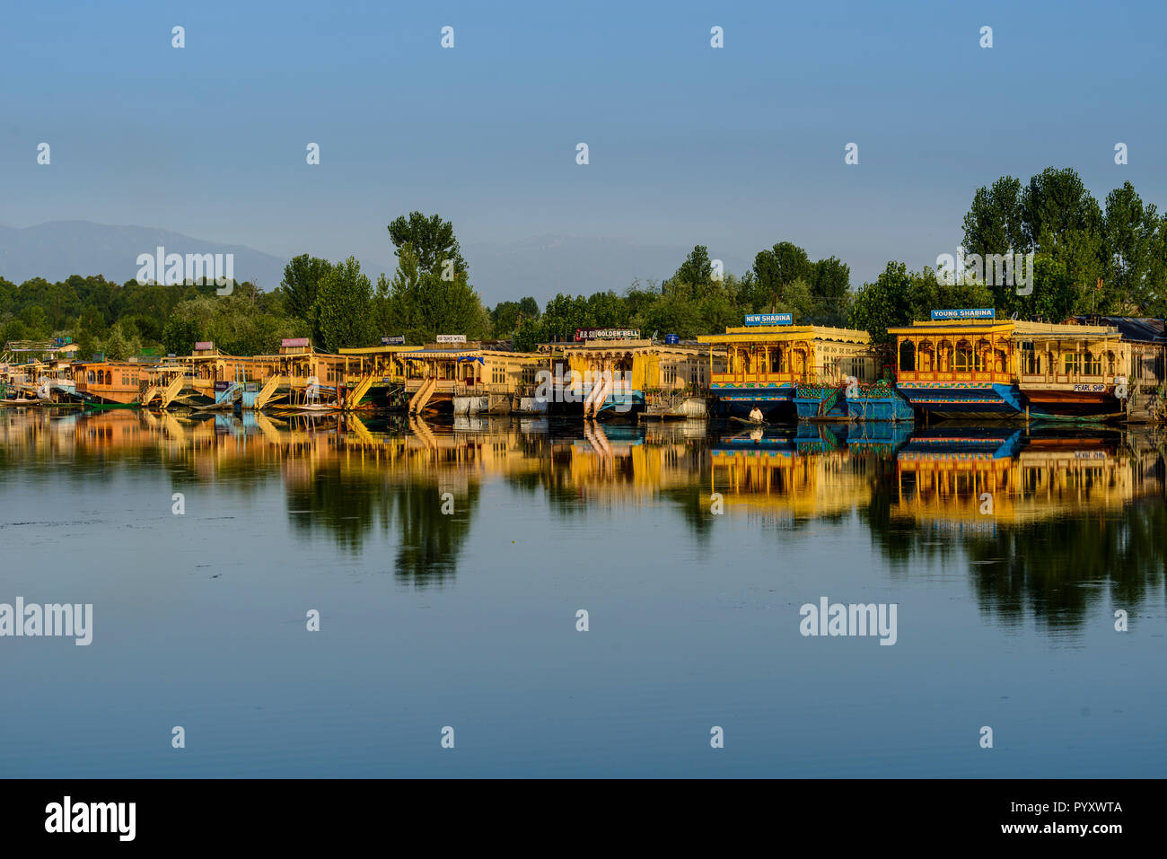 Case galleggianti per l'affitto, ancorato a dal lago e il mirroring in acqua, sono la principale attrazione per i turisti che visitano il Kashmir Foto Stock