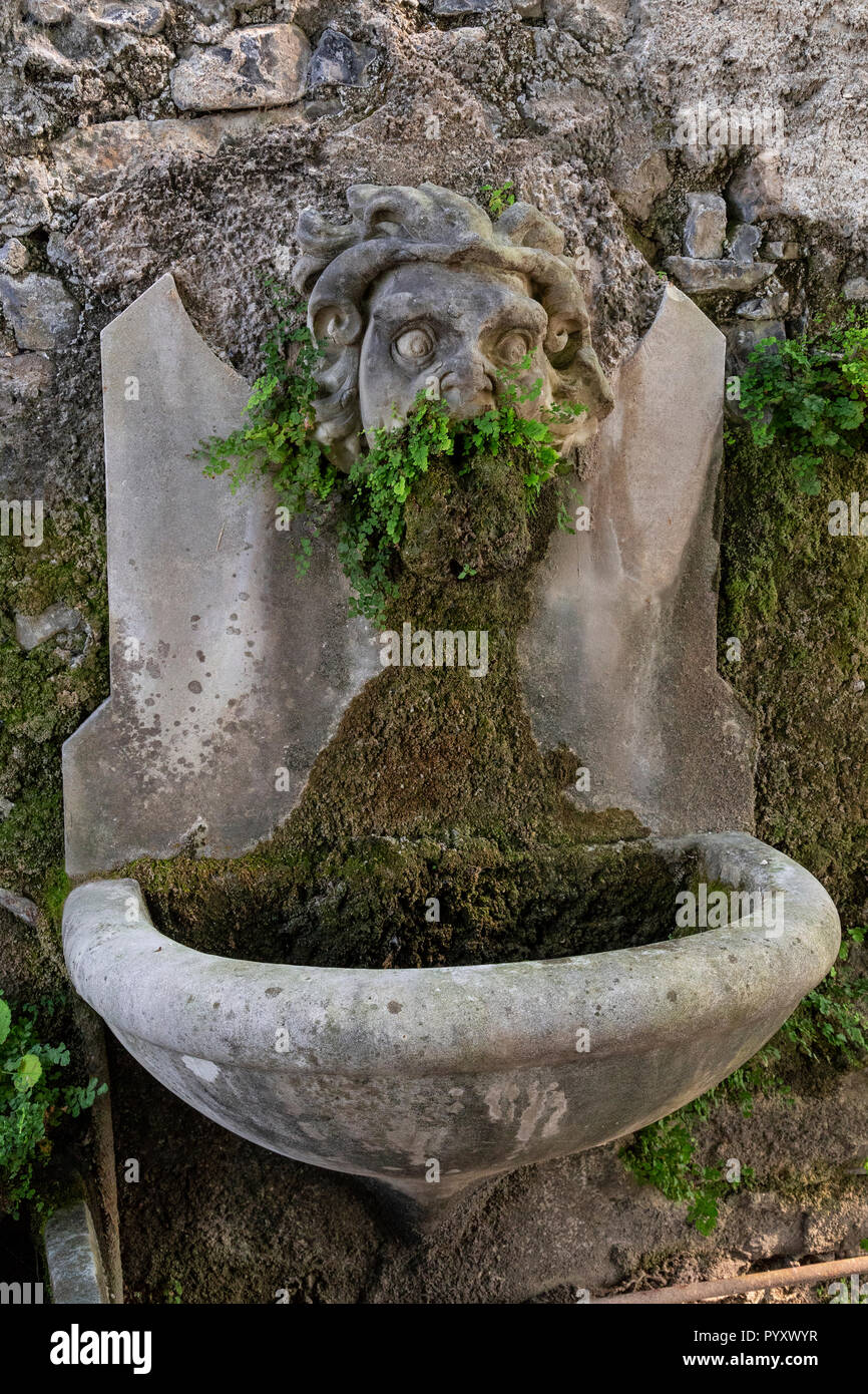 Vecchio scolpita in pietra faccia a Villa Monastero, Varenna sul lago di Como, Italia Foto Stock