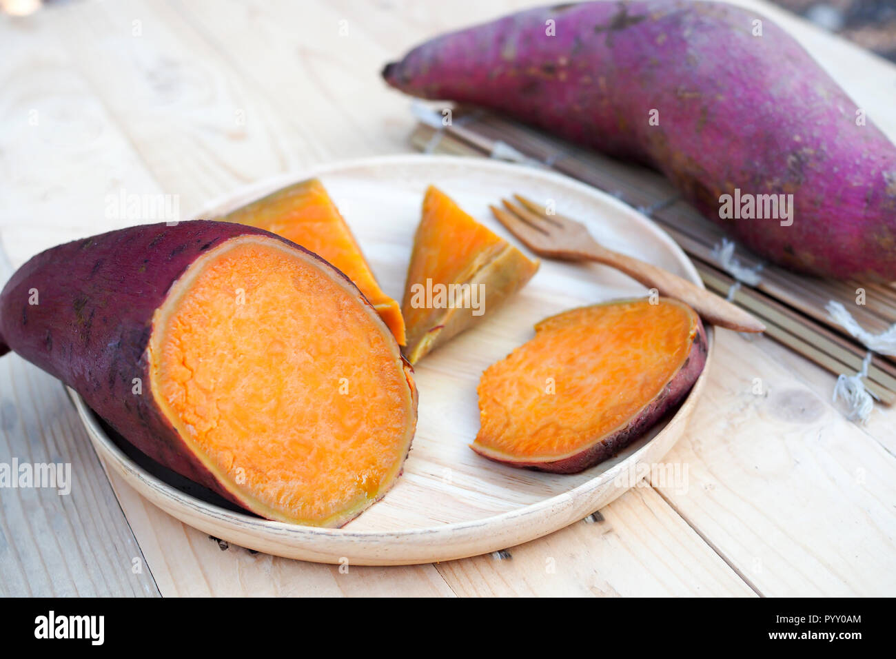 Patate dolci cotte a vapore in legno piatto sul tavolo in legno Foto Stock