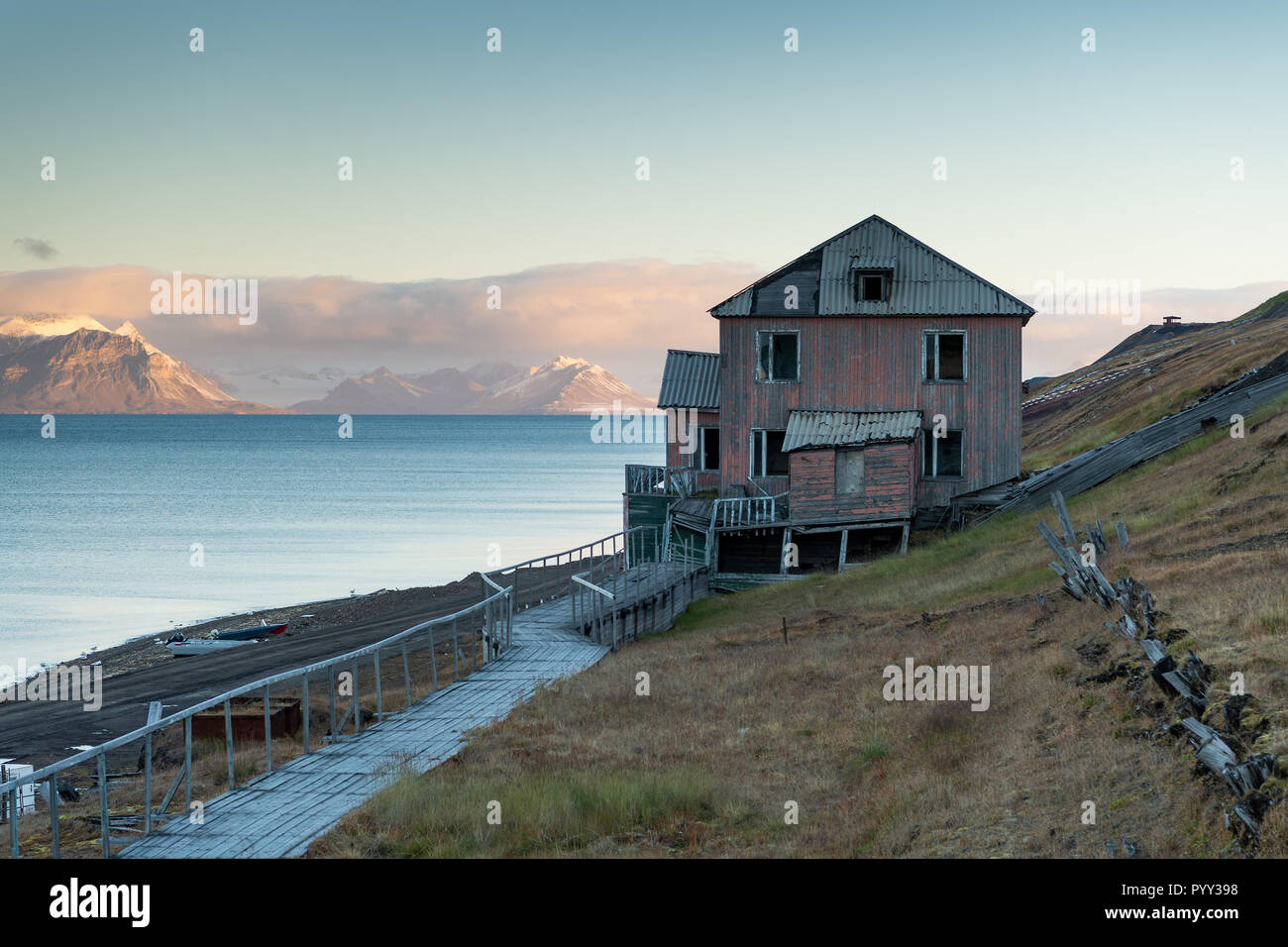 Vacante, fatiscente edificio residenziale all'alba, russo dei minatori insediamento Barentsburg, Isfjorden, Spitsbergen, Svalbard Foto Stock
