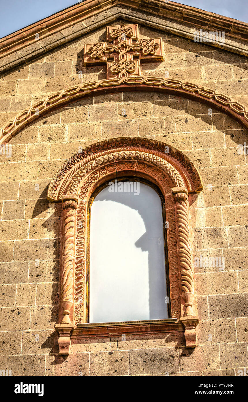 Finestra sotto il tetto,coperto con un modellato cornice ovale e openwork croce sulla chiesa di San Mesrop Mashtots nel villaggio di Oshakan Foto Stock