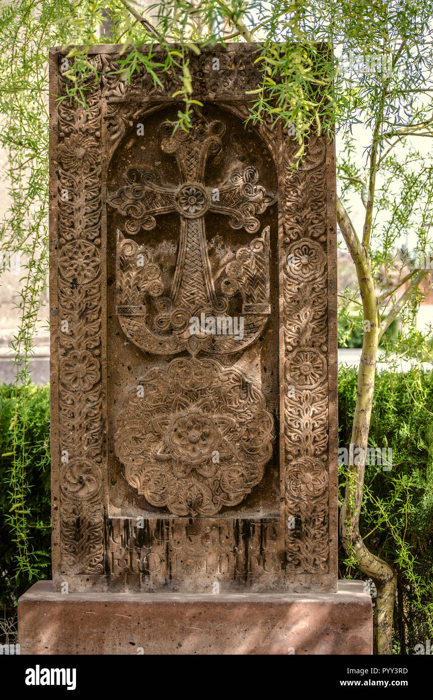 Medievale croce di pietra sotto l'albero di salice nel giardino della chiesa di San Mesrop Mashtots nel villaggio di Oshakan Foto Stock