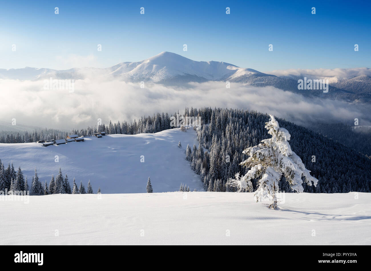 Rifugi di montagna su una collina innevate. Paesaggio invernale in una giornata di sole Foto Stock