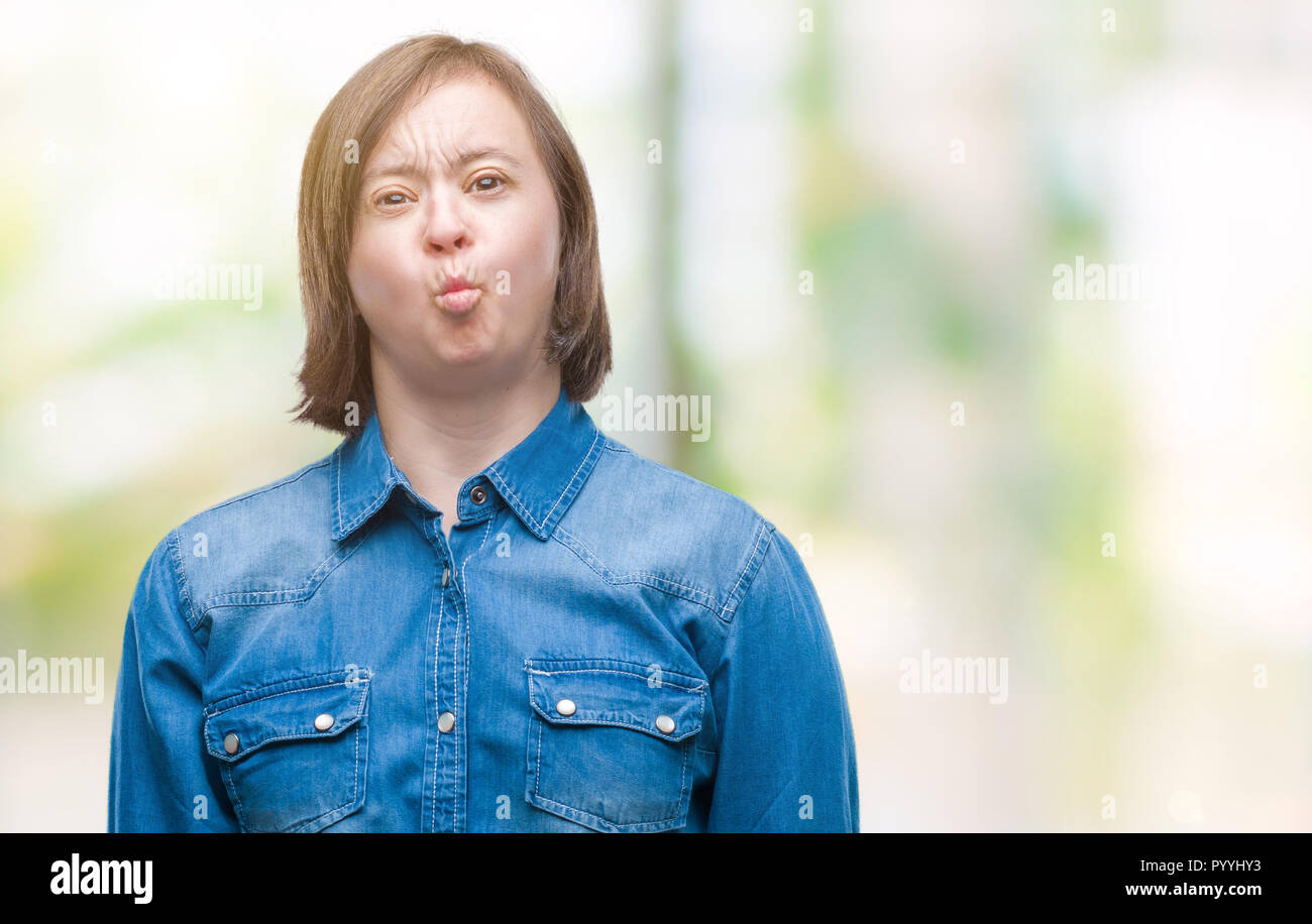 Giovane donna adulta con la sindrome di down su sfondo isolati rendono i pesci il viso con le labbra, pazzo e comico gesto. Espressione divertente. Foto Stock