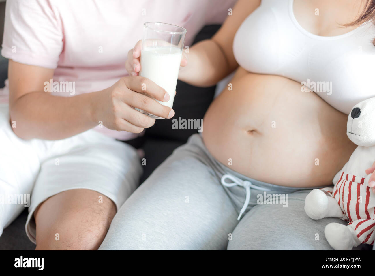 Asian donna incinta con grande pancia. Rilassarsi a casa con il marito. Foto Stock