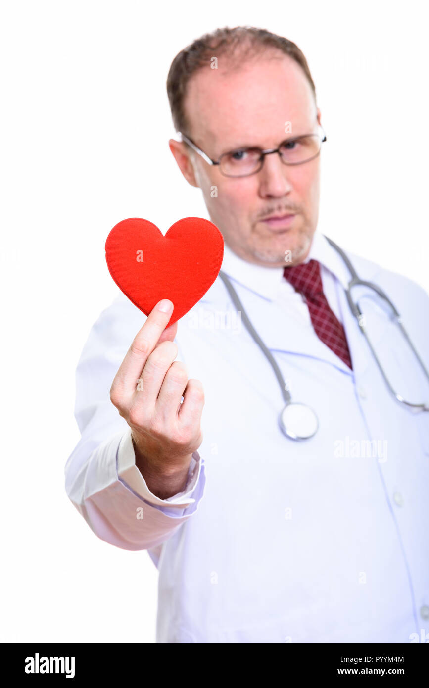 Studio shot di uomo maturo medico tenendo cuore rosso con focus su Foto Stock