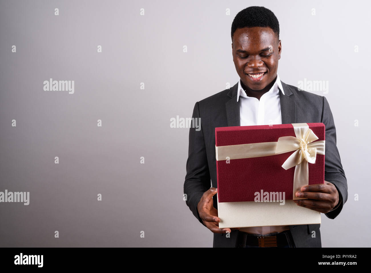 Giovane imprenditore africano indossare tuta contro uno sfondo bianco Foto Stock