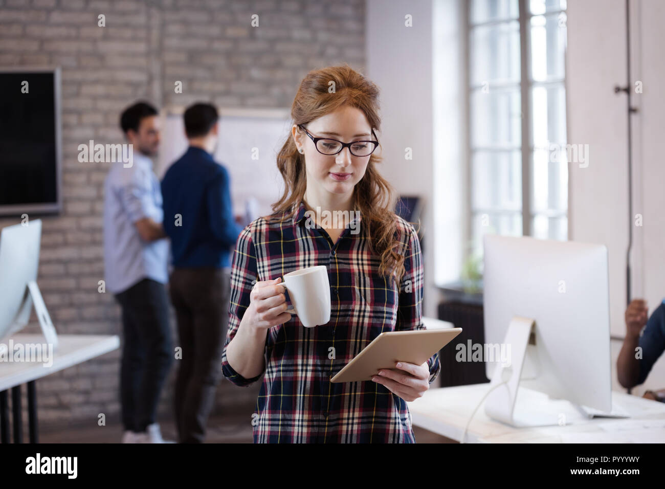 Giovane architetto attraente lavorando in ufficio moderno Foto Stock