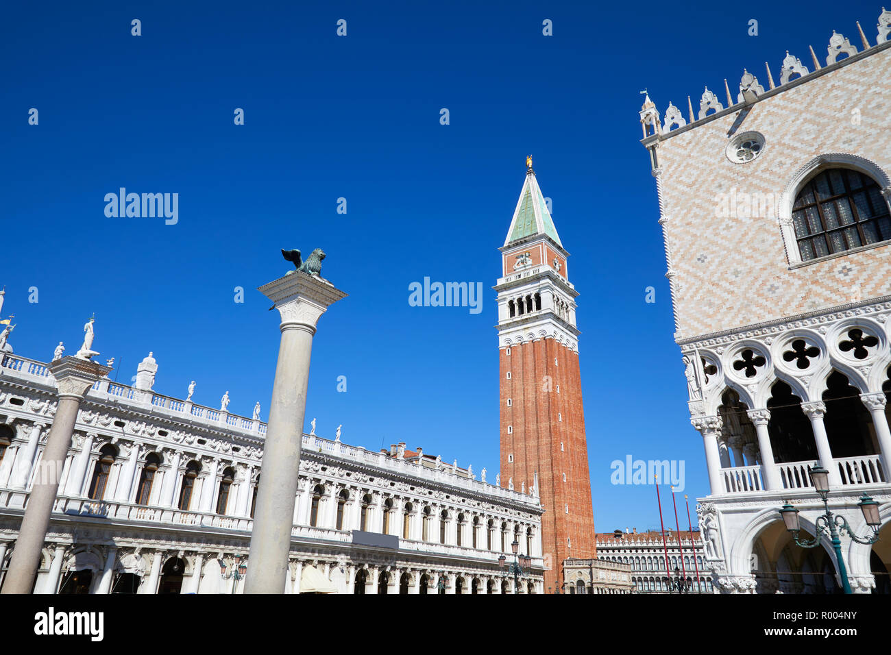 San Marco della torre campanaria e lion staue su colonna, Nazionale Biblioteca Marciana e Palazzo Ducale un ampio angolo di visione, cielo blu chiaro a Venezia, Italia Foto Stock