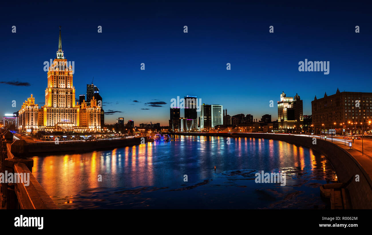 Vista aerea di alberghi con fiume e grattacieli di Mosca, Russia. Tramonto sulla città. Cielo blu chiaro Foto Stock