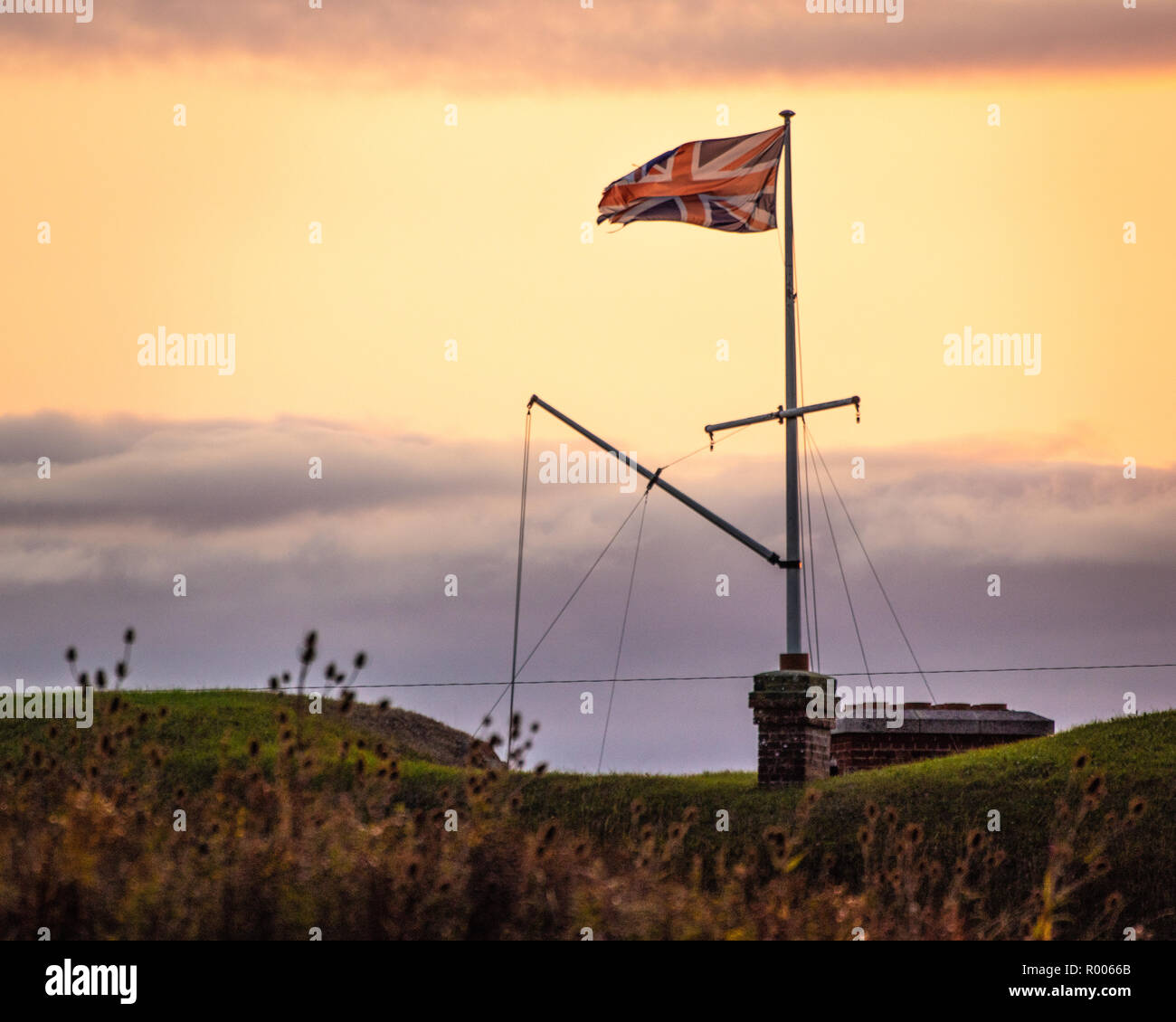 Un Union Jack flag volare alto su un palo di bandiera Foto Stock