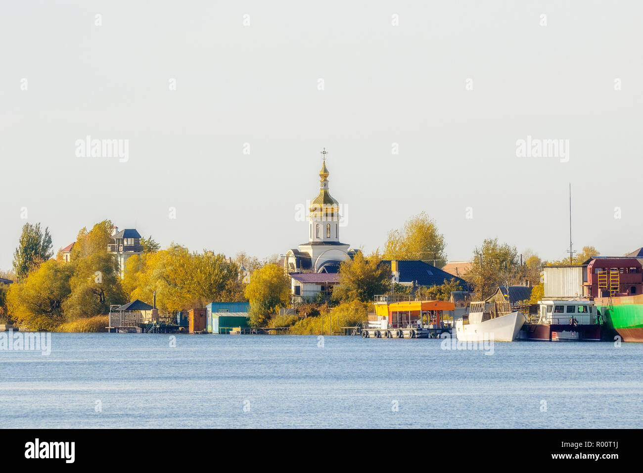 Immagine della Chiesa sulle rive del fiume in autunno presso il molo Foto Stock
