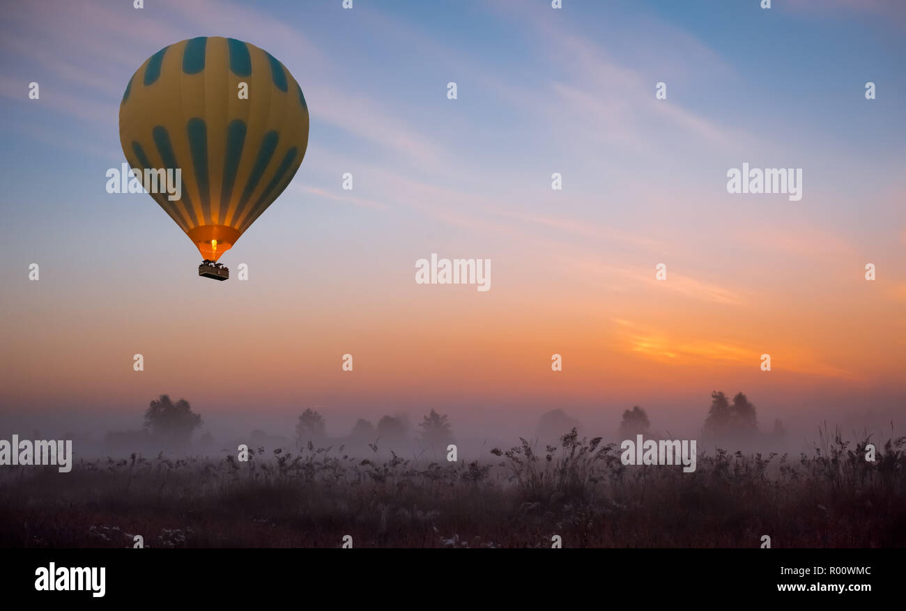 Mongolfiera Volare a sunrise giallo Foto Stock