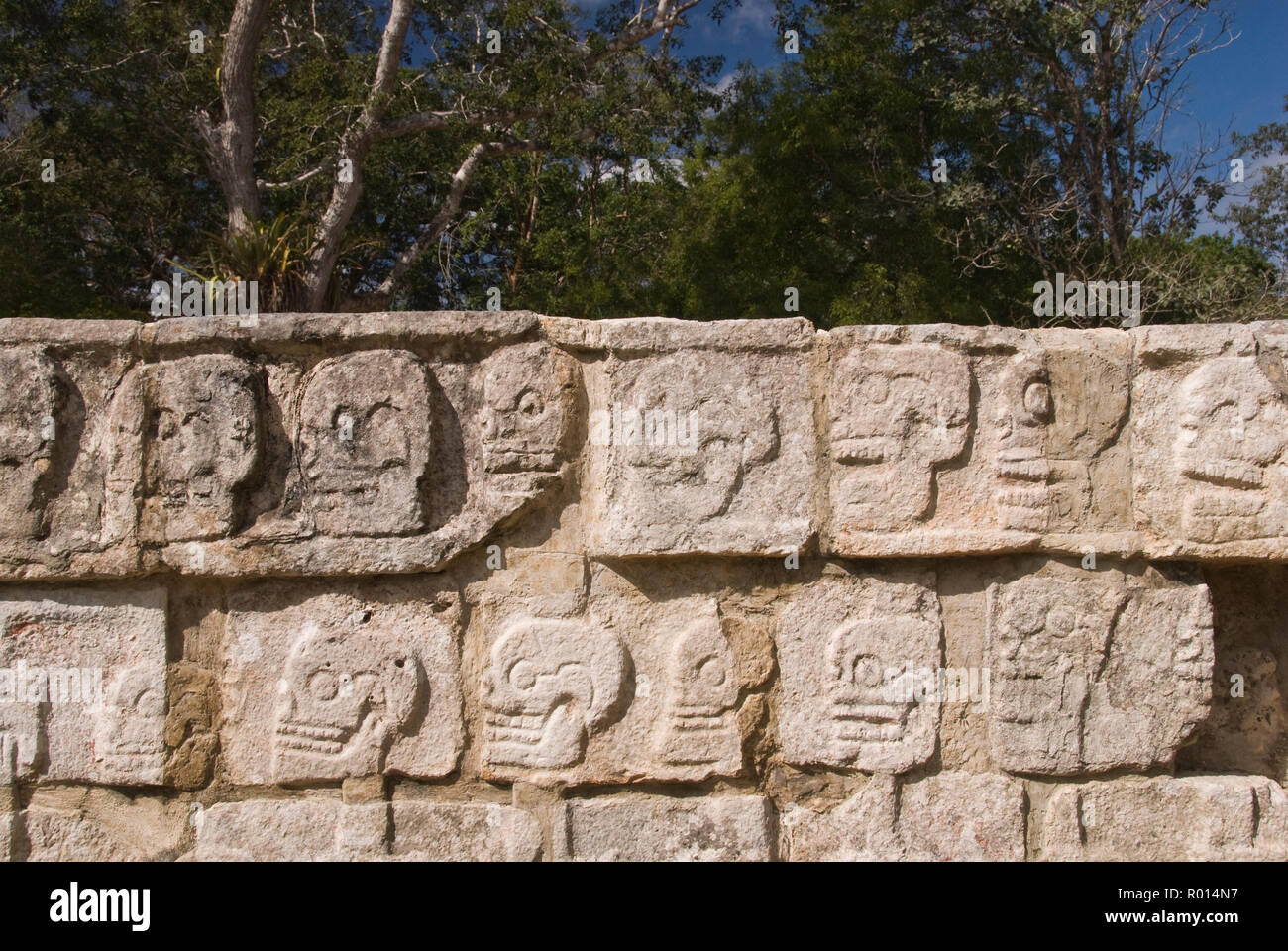 Il teschio di pietra (piattaforma tzompantli) decorato con immagini scolpite di teschi a Chichen Itza, Yucatan, Messico. Foto Stock