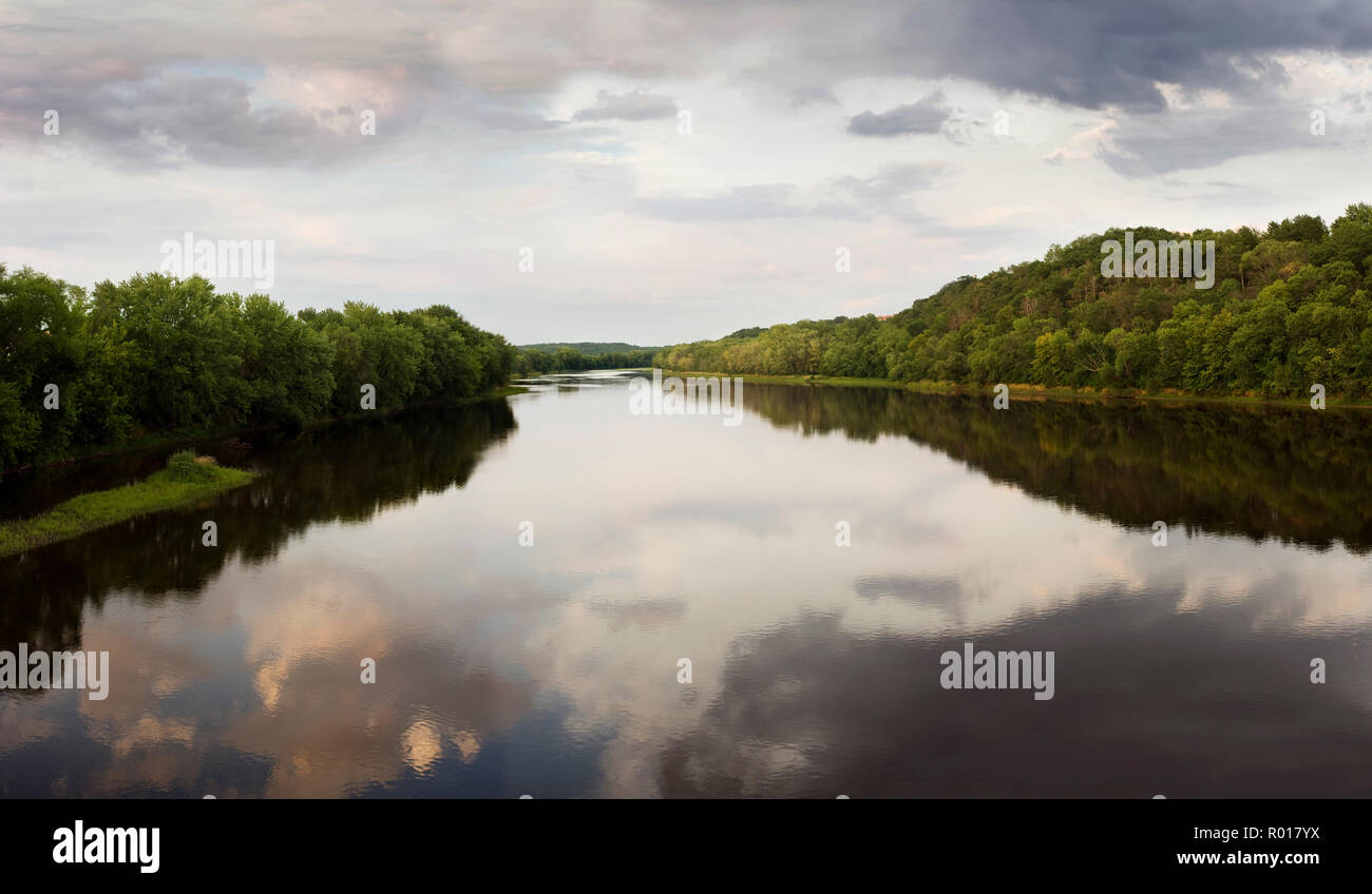 Alberi che fiancheggiano la riva di un fiume calmo. Foto Stock
