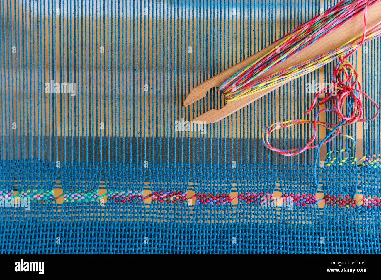 Pizzi spagnoli tessitura su liccio rigida del telaio blu con fili di ordito e di trama colorata Foto Stock