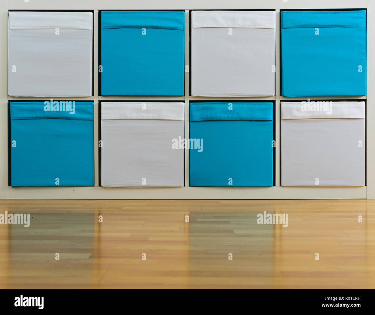 Ripiano di bianco e blu con scatole su un lucido pavimento di legno Foto Stock
