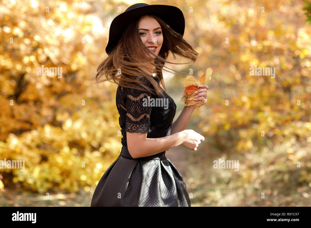 Bella donna in abito nero e il cappello in autunno Foto stock - Alamy