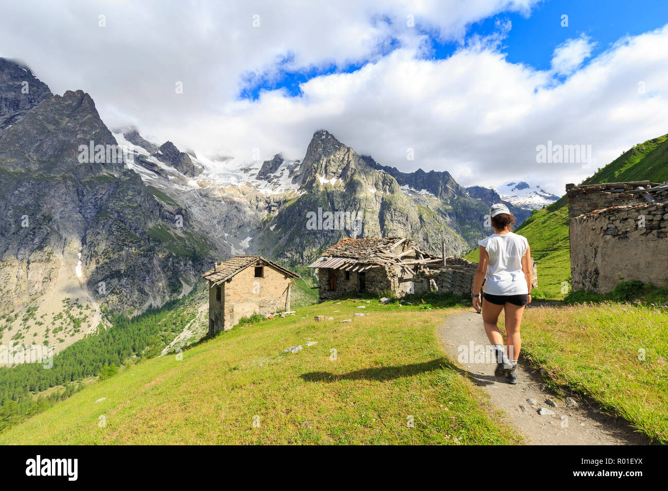 Un escursionista corre lungo un percorso in Val Ferret. Rifugio Bonatti, Val Ferret, Courmayeur, in Valle d'Aosta, Italia, Europa Foto Stock