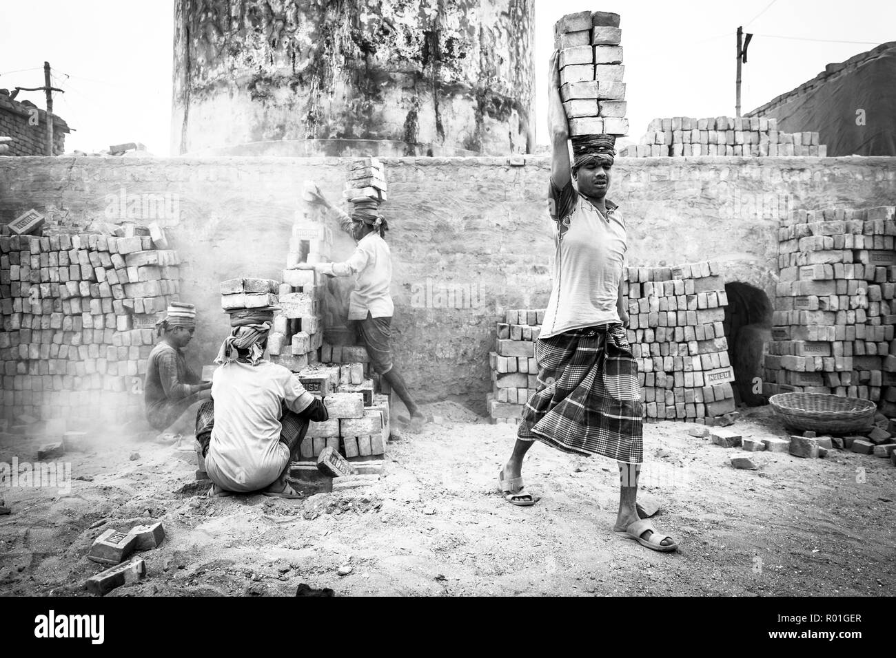 Lavoratori con mattoni sulle loro teste in fornace, monocromatici, a Dacca in Bangladesh Foto Stock