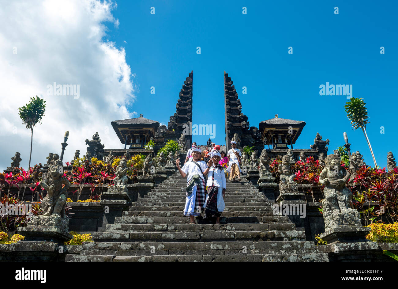 Due ragazzi Balinese andare giù per le scale, split gate, Candi bentar, Tempio madre Besakih Bali Induismo, Pura Penetaran Agung Besakih Foto Stock