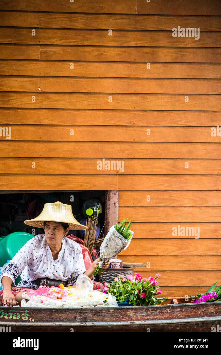 Damnoen Saduak, Tailandia - 8 Ottobre 2018: Donna venditore di fiori al mercato galleggiante. Il mercato è molto conosciuta destinazione turistica. Foto Stock