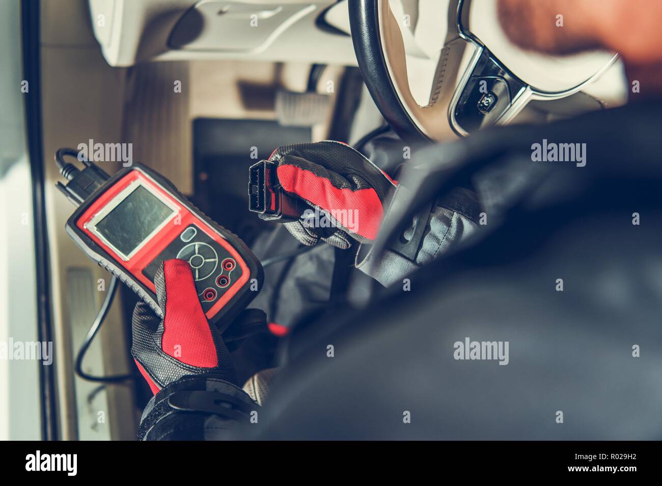 Servizio Auto attrezzo di diagnosi nelle mani della manutenzione del veicolo lavoratore. Computer auto Errore di lettura utilizzando il dispositivo mobile. Foto Stock
