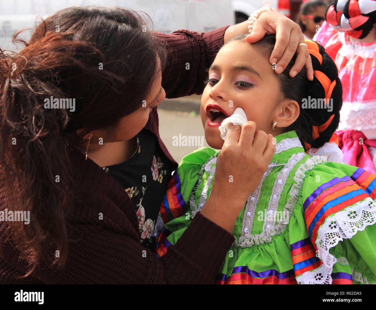Una madre prepara la sua ragazza per un messicano tradizionale spettacolo di danza Foto Stock