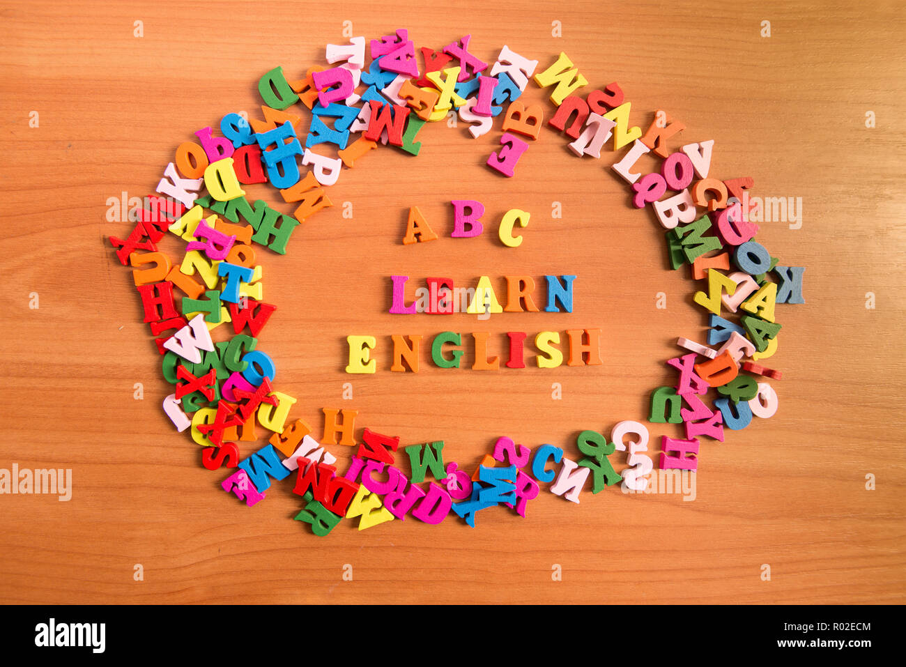ABC imparare inglese lettere di legno intorno a un mucchio di altre lettere sopra il tavolo superficie della scheda Foto Stock