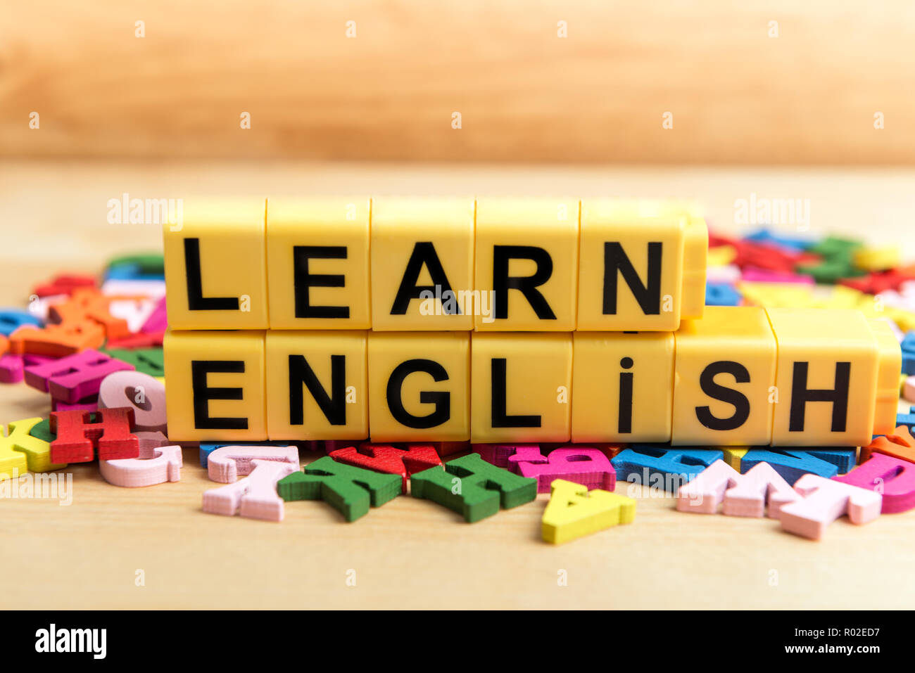 Impara Inglese messaggio vicino a un mucchio di altre lettere su pannello di legno sfondo Foto Stock