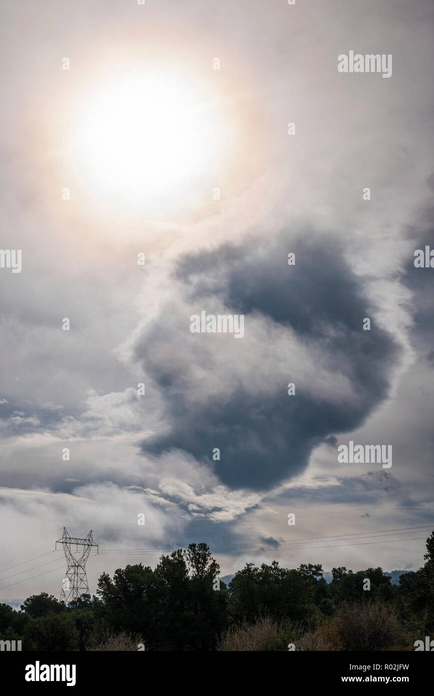 Insolito sun & formazioni di nubi; linee elettriche ad alta tensione & Tower nel centro di Colorado; USA Foto Stock