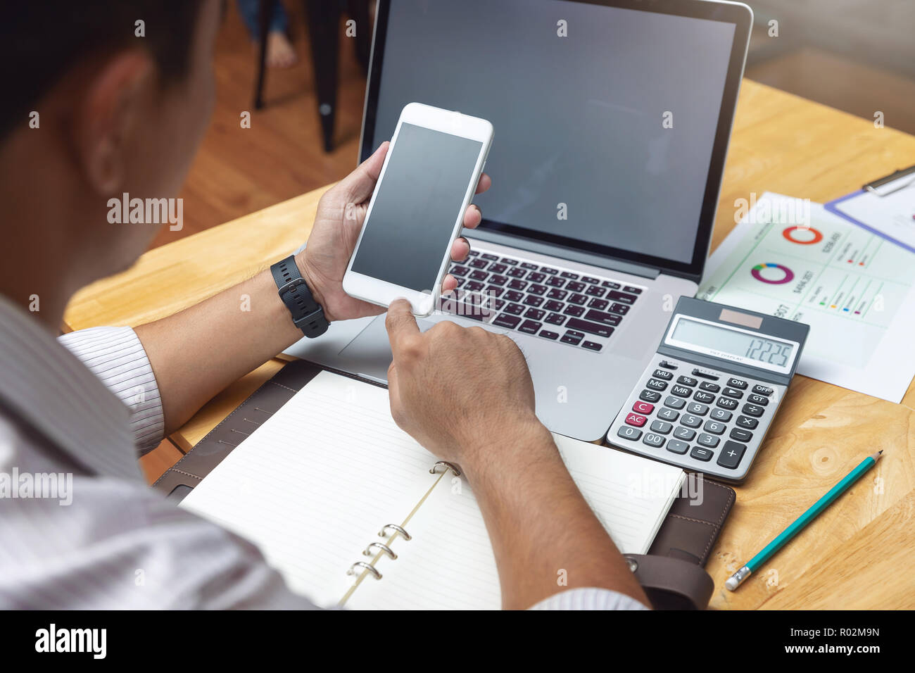 Affari e finanza concetto, imprenditore tenendo lo smartphone e discutere di vendita grafico analisi nel coffee shop Foto Stock