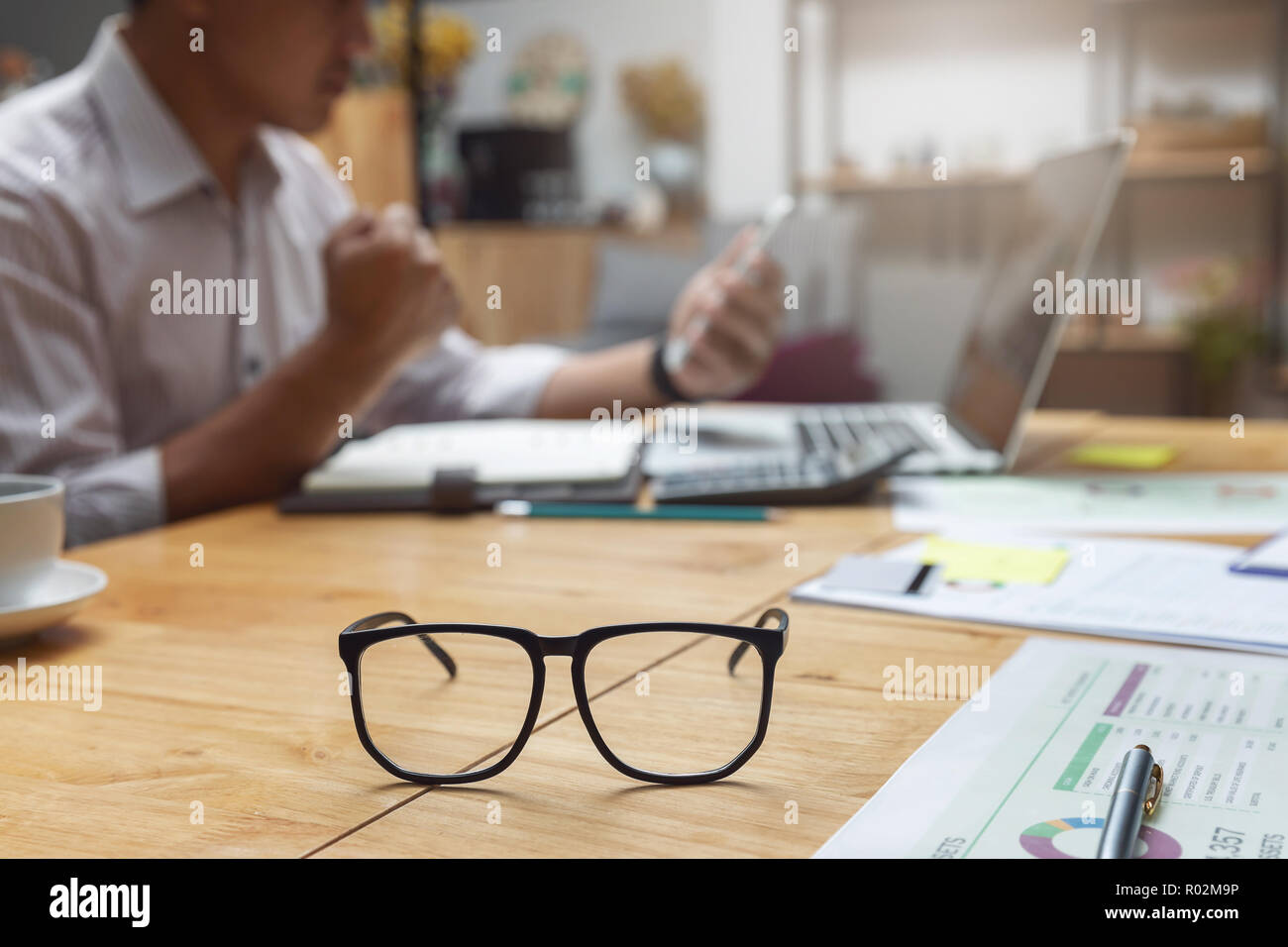 Affari e finanza concetto, imprenditore tenendo lo smartphone e discutere di vendita grafico analisi nel coffee shop Foto Stock