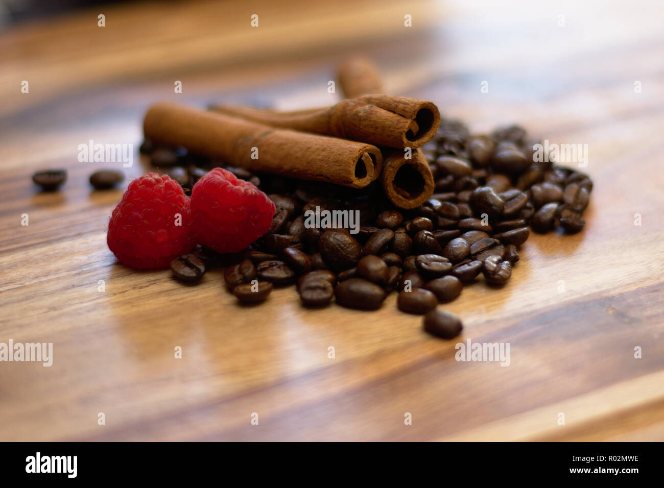Bastoncini di cannella con i chicchi di caffè e di lamponi Foto Stock