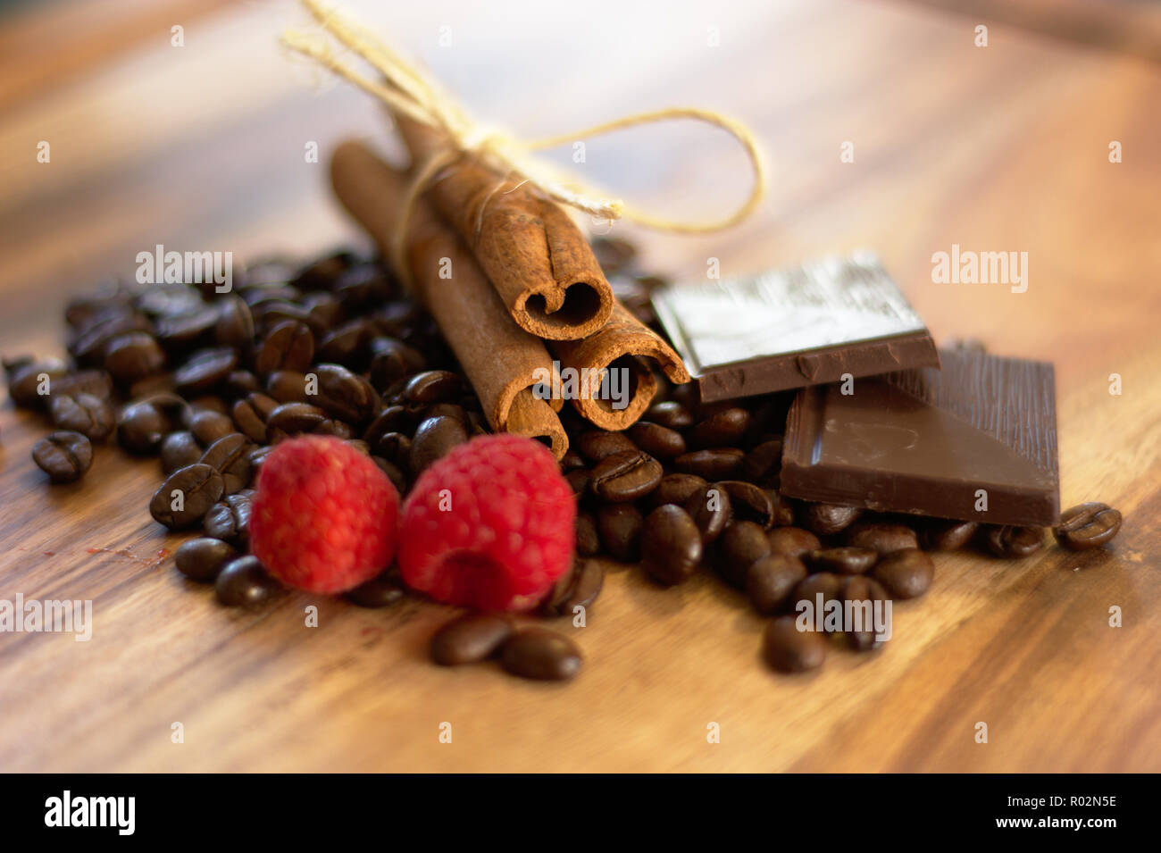 Bastoncino di cannella bundle con i chicchi di caffè, cioccolato e lamponi Foto Stock
