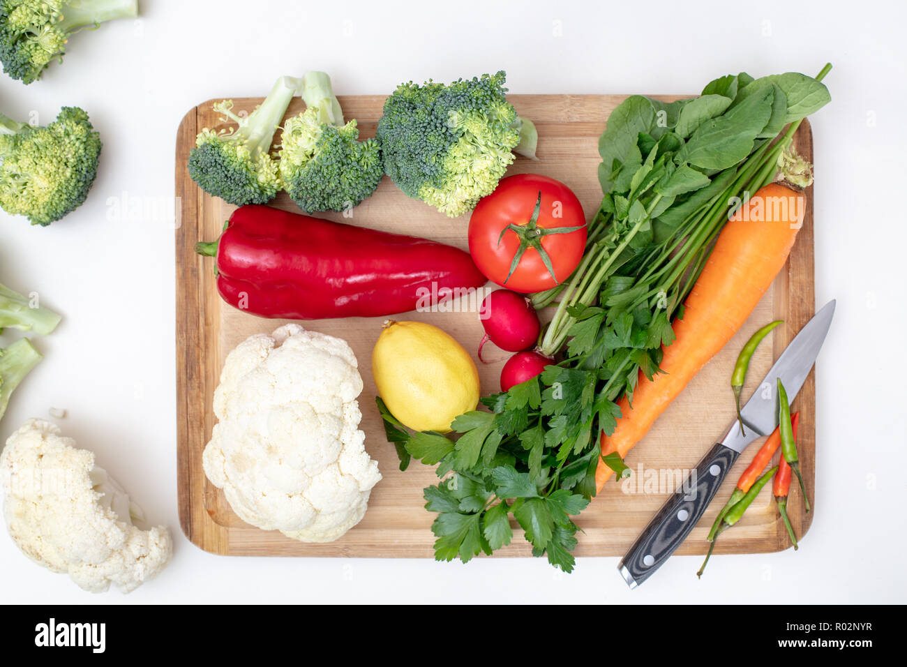 Organici alimentari healtyy concetto di fresche verdure colorate su di un tagliere di legno su uno sfondo bianco con shados , appartamento , laici vista superiore con kni Foto Stock