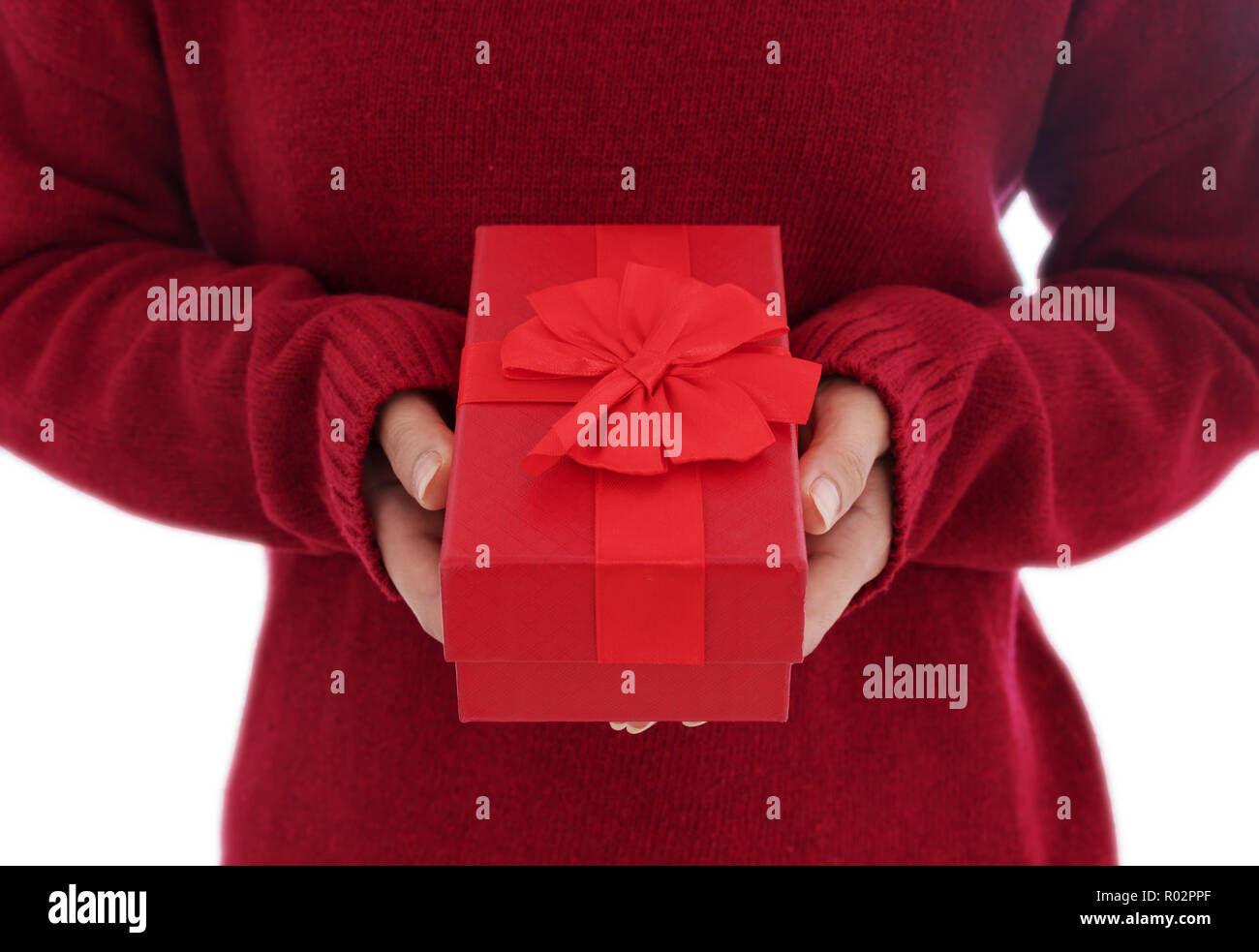 Donna che mantiene un regalo in un gesto di dare isolati su sfondo bianco Foto Stock