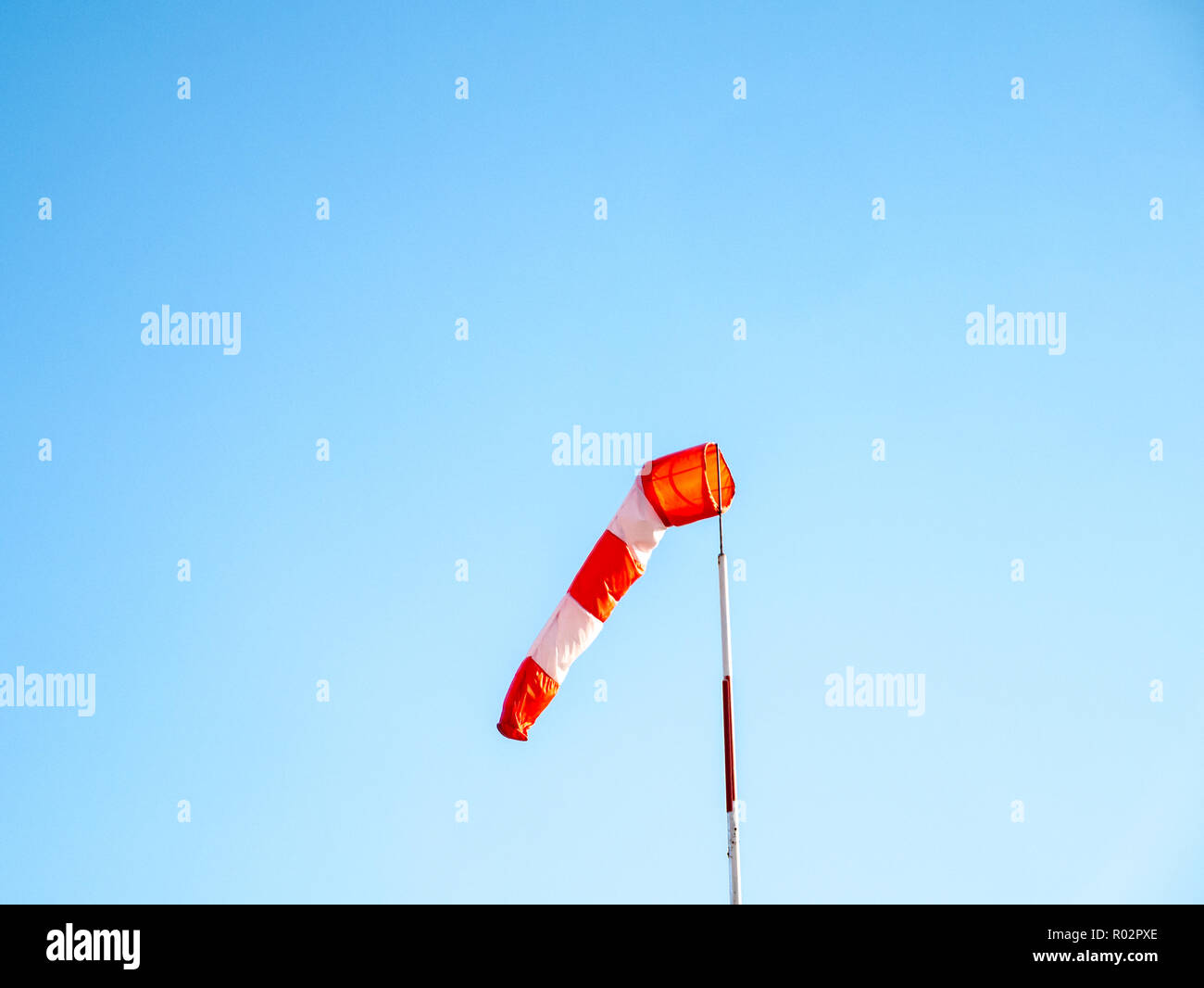 Manica a vento, leggermente riempito con aria, attaccato al bianco-rossi del montante di sollevamento in aliante airfield sotto il cielo blu. Foto Stock