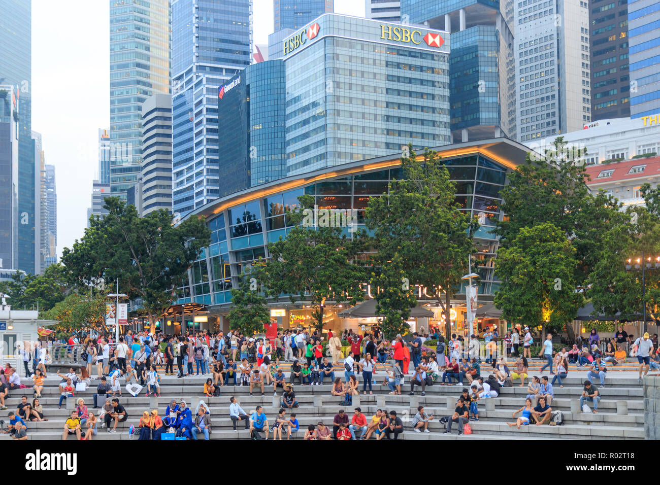 La gente seduta vicino alla zona del Merlion in Singapore Foto Stock