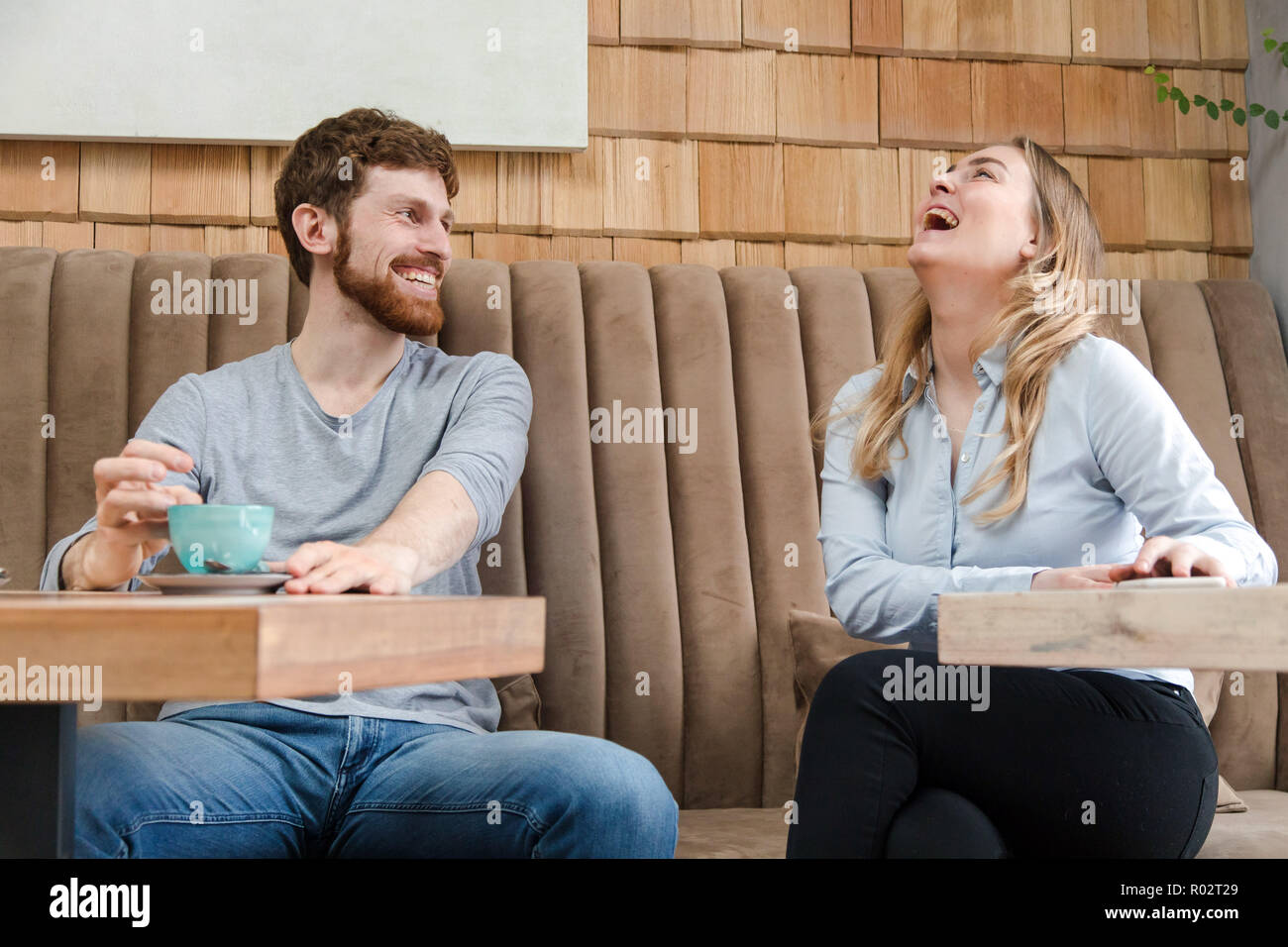 Ridendo giovane su data nel coffee shop Foto Stock