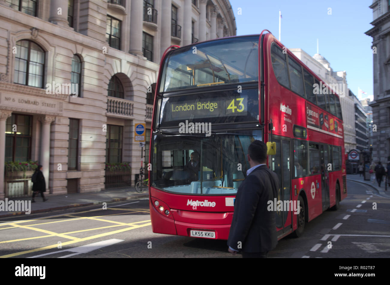 Uomo che guarda un double decker bus in Londra, Regno Unito. Foto Stock
